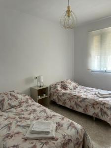 - une chambre avec deux lits, une lampe et une fenêtre dans l'établissement Casa Ancá Los Abuelos, à Rute