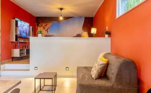 un soggiorno con pareti arancioni, divano e tavolo di Maison de vacances a Dalhem