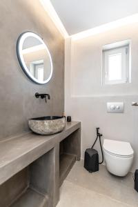 uma casa de banho com um lavatório e um espelho em Marble Arch Apartments em Naxos Chora