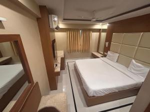 Habitación pequeña con cama y TV. en Hotel Vinnie, en Jaipur