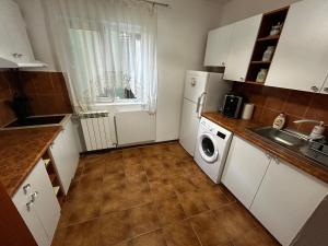 cocina con nevera blanca y lavavajillas en Elina apartament, en Drobeta-Turnu Severin