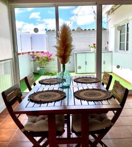 een houten tafel met stoelen en een vaas met een plant bij Roque's House in Telde