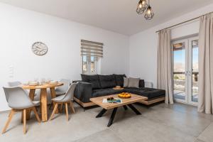 uma sala de estar com um sofá preto e uma mesa em Marble Arch Apartments em Naxos Chora