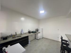 eine Küche mit einer Spüle und einem Kühlschrank in der Unterkunft Executivo Veneza in Ipatinga