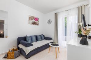 プーラにあるApartman Sunny Lenaの青いソファと窓のあるリビングルーム