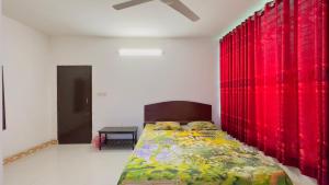 a bedroom with a bed with red curtains at Hotel Priyatama Residential in Dhaka +10 photos