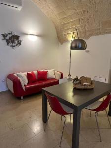 a living room with a red couch and a table at Alle volte… in Bisceglie