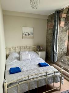 sypialnia z łóżkiem z niebieskimi poduszkami w obiekcie Criccieth Cheapest Seaview Apartment Relax and Rejuvenate w mieście Criccieth