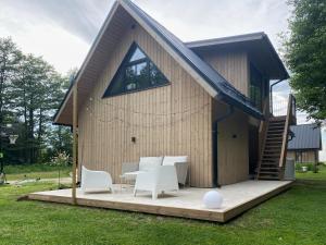 a small house with white chairs and a table at Heinaläku puhkemaja loft in Paope
