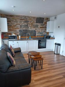 ein Wohnzimmer mit einem Sofa und einer Küche in der Unterkunft Craiglea Thistle in Killin