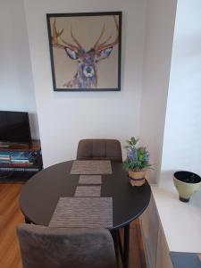 uma mesa de jantar com cadeiras e uma fotografia de um veado em Craiglea Thistle em Killin