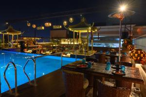 ein Resort mit einem Pool und einer Bar in der Nacht in der Unterkunft Hotel Maharaja Regency in Ludhiana