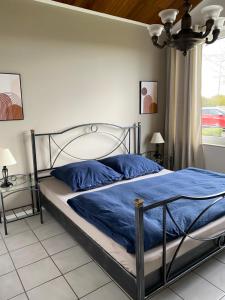 a bedroom with a bed with blue sheets and a window at Ferienwohnung Ebersburg in Rabennest