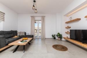 a living room with a couch and a tv at Marble Arch Apartments in Naxos Chora