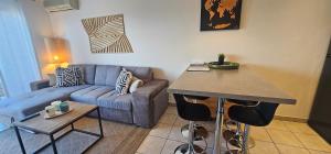 a living room with a couch and a table at Appartement 2 pièces Cosy au calme climatisé 3 étoiles in Fréjus +4 photos