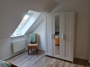 ein Dachzimmer mit Schrank und Fenster in der Unterkunft Treeneperle in Schwabstedt