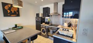 uma cozinha com um fogão, um lavatório e um balcão em Appartement 2 pièces Cosy 20 min à pied de la plage em Fréjus