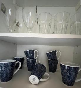 a row of glasses and cups on a shelf at Lichtdurchflutete 130qm Wohnung in Weißenohe