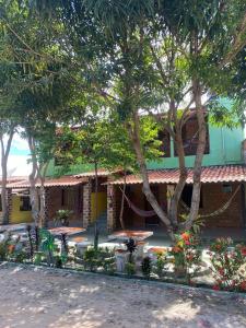 um edifício com mesas, árvores e flores em Recanto Sapoti em Barreirinhas