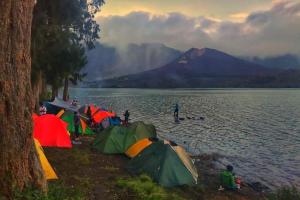 a group of tents on the shore of a lake at Al Sasaki in Tetebatu