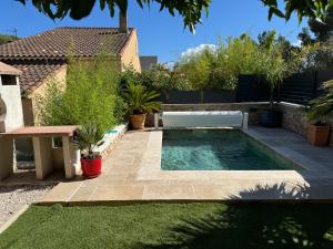 een klein zwembad in een achtertuin met een bankje bij Villa ,Maison indépendante, avec piscine privative in Puget-sur Argens