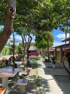 um parque com bancos e árvores e um carro vermelho em Recanto Sapoti em Barreirinhas