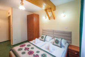 1 dormitorio con 1 cama con sábanas y almohadas blancas en Willa Monte Rosa, en Zakopane