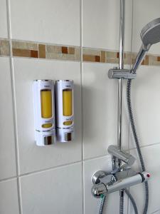 a bathroom with two soap dispensers on a wall at Ferienwohnung am Schwarzwald in Althengstett