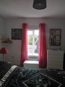 a bedroom with a bed and a window with red curtains at Hillside Residence in Carrick on Shannon