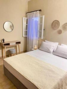 a bedroom with a bed with a desk and a window at Olives Villa in Anopoli Sfakion