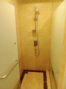 ein Bad mit Dusche, WC und Fliesenboden in der Unterkunft Espana Condo Resort Pattaya in Jomtien Beach + 2 Fotos