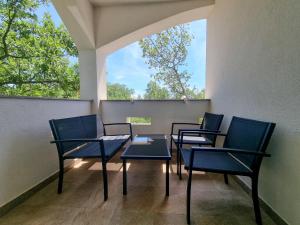four chairs and a table on a balcony at Apartment & Room Danijel in Pinezici