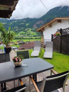 a table and chairs on a patio with a view at Ferienwohnung Zuppinger in Mayrhofen