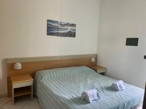 een slaapkamer met een bed met twee handdoeken erop bij SALENTO - Casa vacanza - Torre dell’orso in Torre dell'Orso
