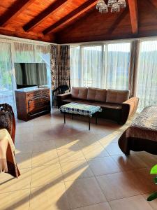 a living room with a couch and a tv at CASA IONUȚ in Borşa