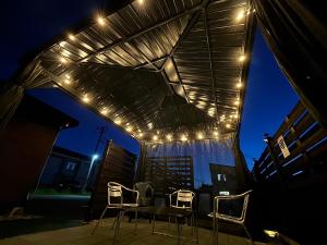 a table and chairs under a pergola with lights at Guest House モモ in Obihiro