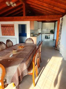 a dining room with a table and chairs and a kitchen at CASA IONUȚ in Borşa