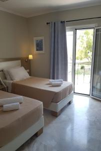 Postel nebo postele na pokoji v ubytování SUNRISE MIDTOWN LEFKADA