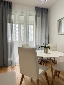ein weißes Esszimmer mit einem Tisch und Stühlen in der Unterkunft Ocean Apartment in Zagreb