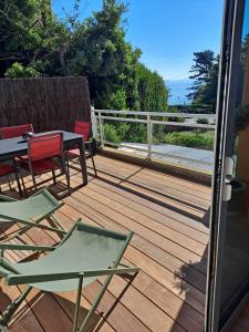 a deck with chairs and a table and a table and chairs at Appartement 2-3 personnes résidence les mimosas Port-Mer Cancale in Cancale +2 photos