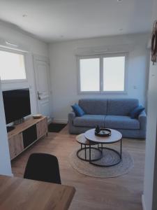 a living room with a couch and a table at Appartement 2-3 personnes résidence les mimosas Port-Mer Cancale in Cancale