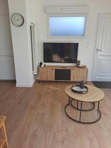 a living room with a flat screen tv and a table at Appartement 2-3 personnes résidence les mimosas Port-Mer Cancale in Cancale