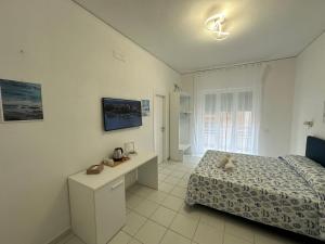 - une chambre avec un lit et un bureau dans l'établissement La Vesuviana, à Castellammare di Stabia