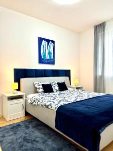 a bedroom with a large bed with a blue headboard at Ocean Apartment in Zagreb