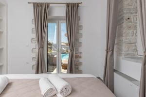 a bedroom with a bed and a large window at Marble Arch Apartments in Naxos Chora +93 photos