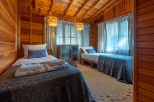 a bedroom with two beds in a wooden cabin at Naturelife Bungalows & SPA in Cıralı