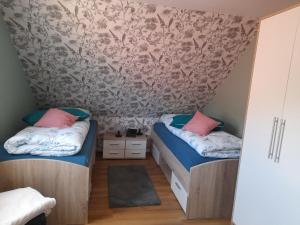 two beds in a small room with pink and blue pillows at Angelikas Ferienparadies Angelika OG in Haselünne