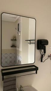 a mirror above a sink in a bathroom at FLEXI Staycation in Manila