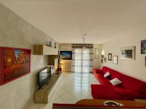 un salon avec un canapé rouge et une télévision dans l'établissement Venice Travel Dream - apartment, à Mestre