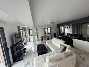 un soggiorno con divano bianco e tavolo di Magnifique Villa avec piscine Beaujolais a Gleizé